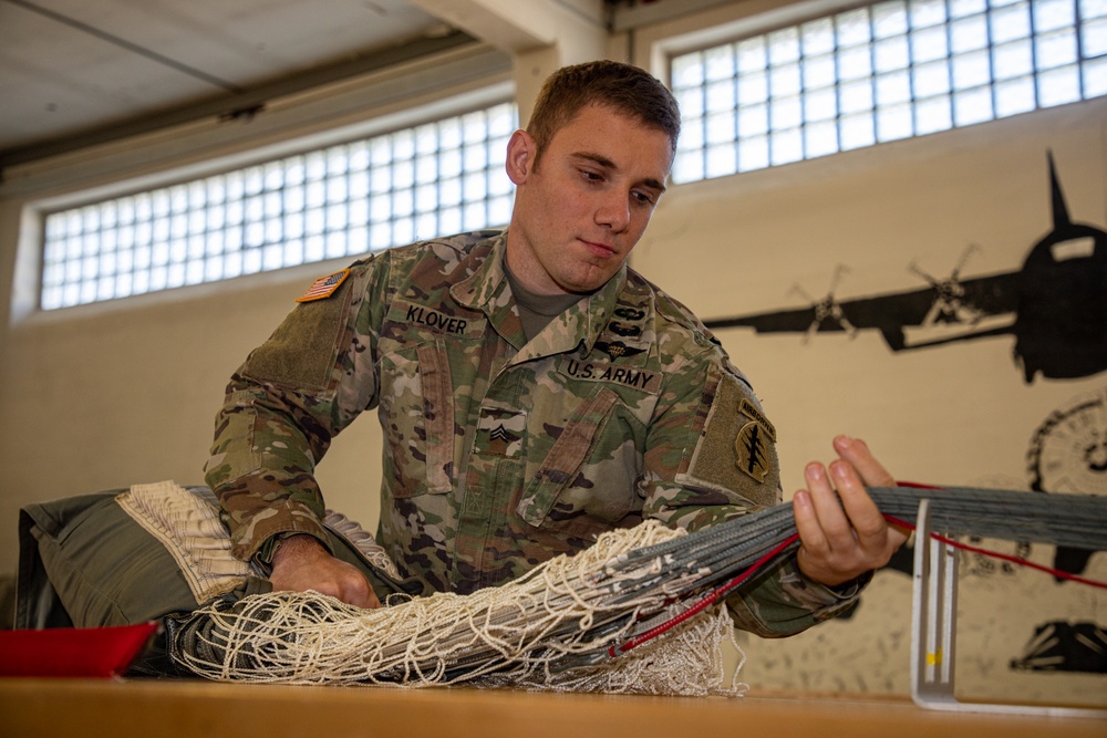 10th SFG riggers pack and inspect parachutes