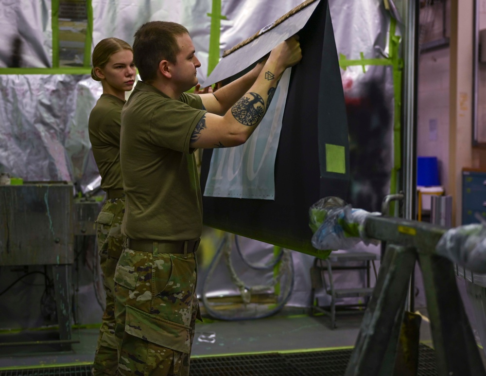 Structurally sound: Aircraft Maintenance Airmen apply a decal