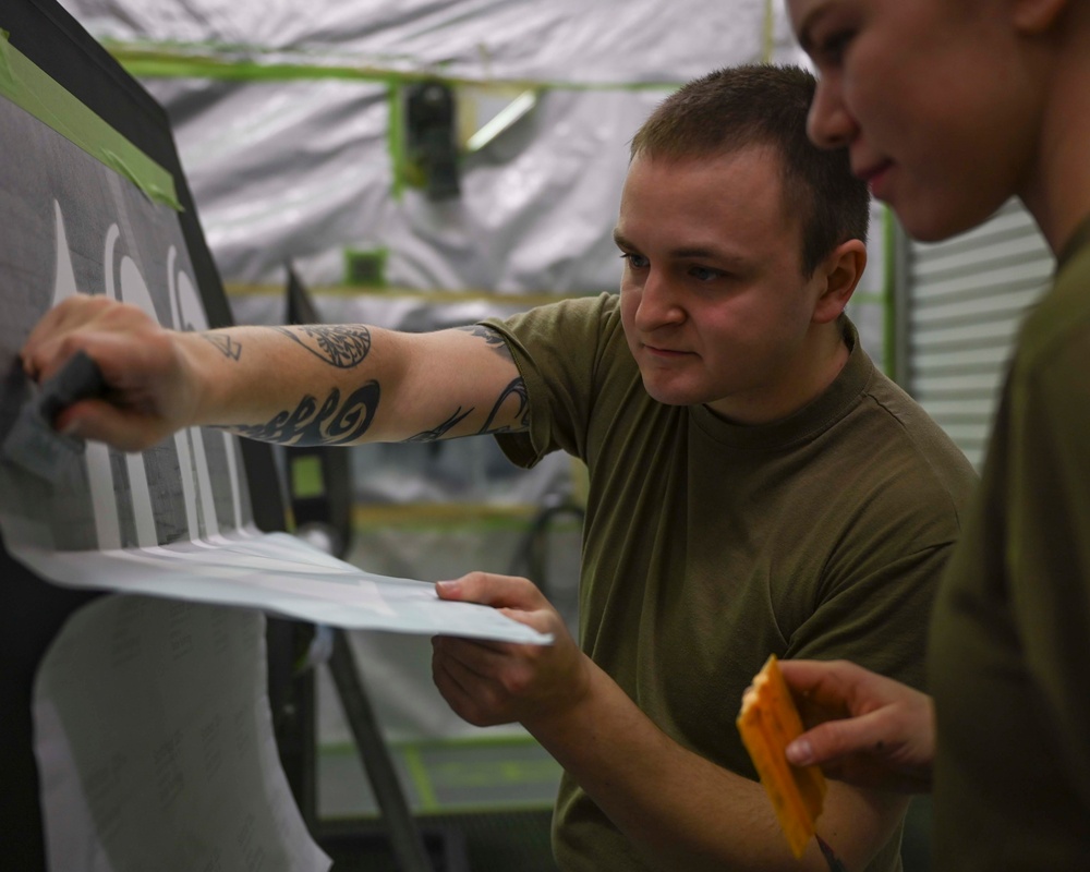 Structurally sound: Aircraft Maintenance Airmen apply a decal