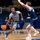 USAFA Men's Basketball Vs Utah State A college basketball game featuring an Air Force Falcons player wearing number 5 dribbling the ball while being defended by an opponent in a dark navy uniform. The game is being played at the Air Force Academy's Clune Arena, identifiable by the 'AF' logos on the court and walls. The scoreboard in the upper left shows 5:29 remaining with the number 9 visible.