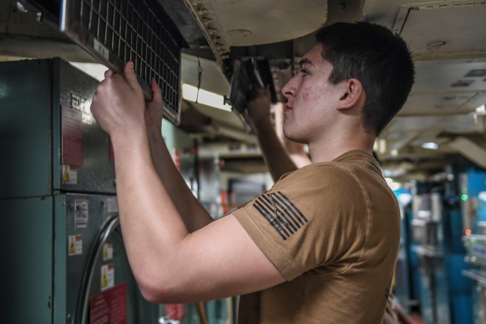 USS Carl Vinson (CVN 70) Sailor cleans