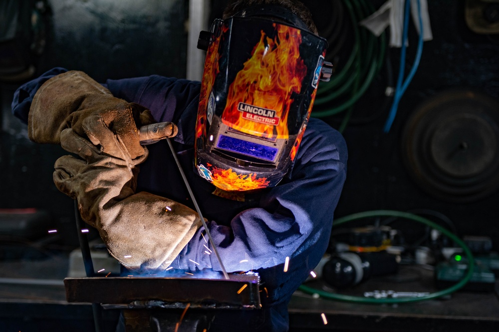 USS Carl Vinson (CVN 70) Sailor Welds in Machine Shop