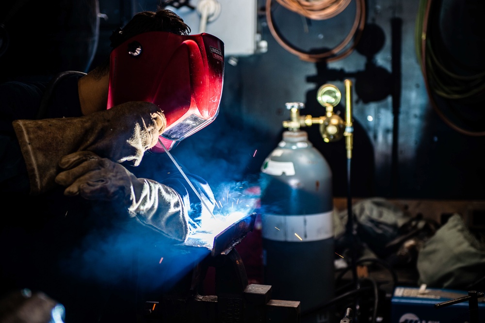 USS Carl Vinson (CVN 70) Sailor Welds in Machine Shop