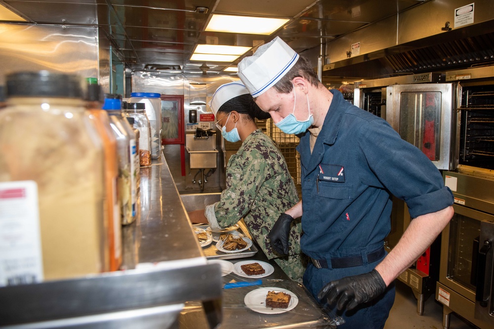 Sailors prepare food in the galley