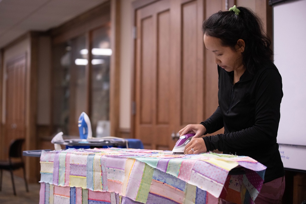 1st SFG (A) spouses with F.I.R.S.T. Mentorship Program craft quilts for displaced Afghan families