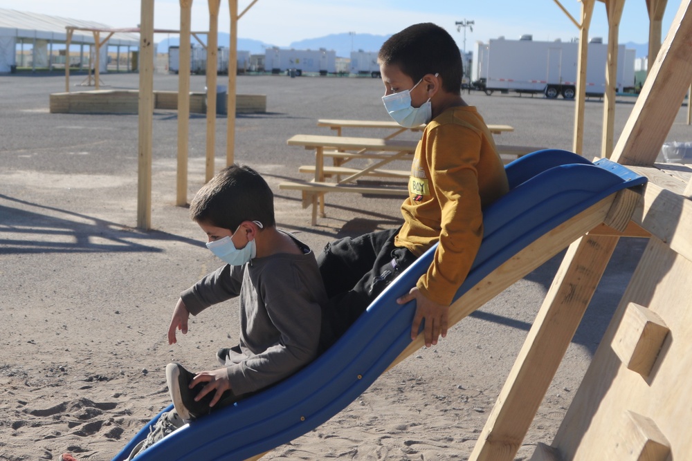 Afghan evacuees play on slides at Task Force Holloman