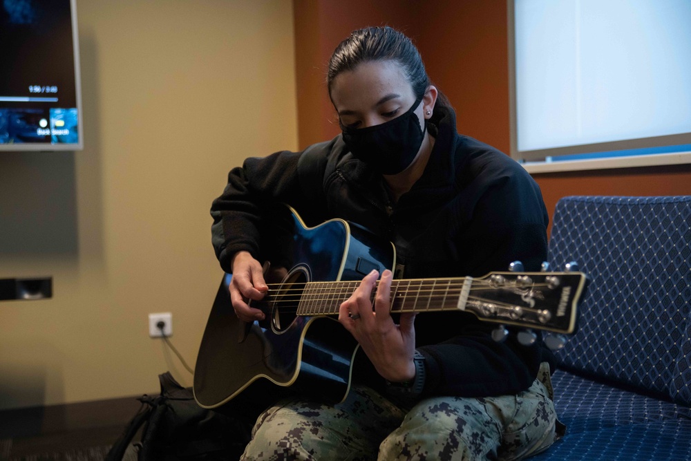Master-at-Arms 2nd Class Mariveliz CruzLopez, from Corozal, Puerto Rico, assigned to Naval Support Facility Redzikowo, play guitar