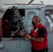 HSC 28 Sailor Preps Machine Gun on Helo