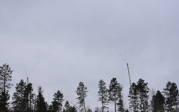 Soldiers set up an antenna to support artillery communication