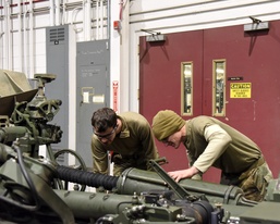 Michigan and Wisconsin National Guard Soldiers maintain howitzer at MATES during Winter Strike