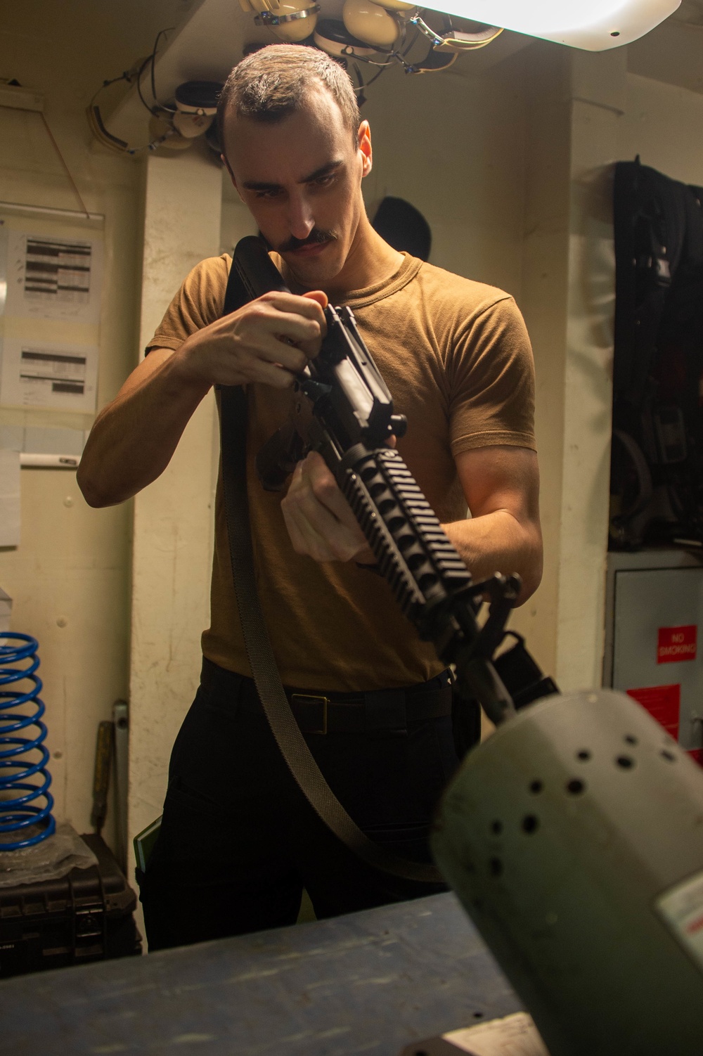 USS Carl Vinson (CVN 70) Sailor Conducts Inspection on an M4 Assault Rifle