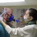 Kerry Watson adjusts a metabolic testing mask on Michael Crossett, both Army Wellness Center health educators, before beginning his assessment.