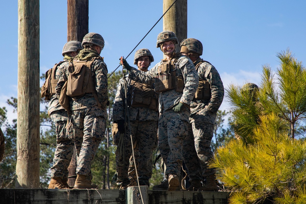 Marine engineers and Navy Seabees construct a one rope bridge during Winter Pioneer 22