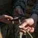 Marine engineers and Navy Seabees construct a one rope bridge during Winter Pioneer 22
