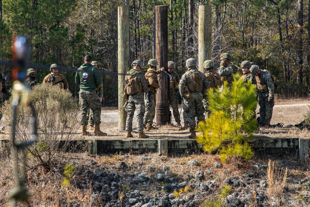 Marine engineers and Navy Seabees construct a one rope bridge during Winter Pioneer 22