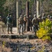 Marine engineers and Navy Seabees construct a one rope bridge during Winter Pioneer 22