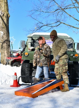 Recruiter plays corn hole game