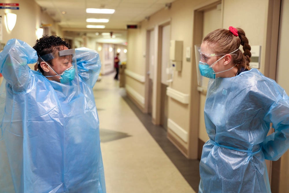 U.S. Air Force nurse and INTEGRIS Health nurse prepare to provide care to a COVID patient