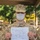 A U.S. Marine recruit in MARPAT desert camouflage uniform and face mask holds up an official NAVMC memorandum receipt for individual weapons and accessories. The document identifies the individual as 'Bainbridge, Arthur' assigned to MCRDSD 1ST ALPHA 1009, with a weapon listed as an M16A4 rifle. Other recruits in similar uniforms and masks are visible in the background.