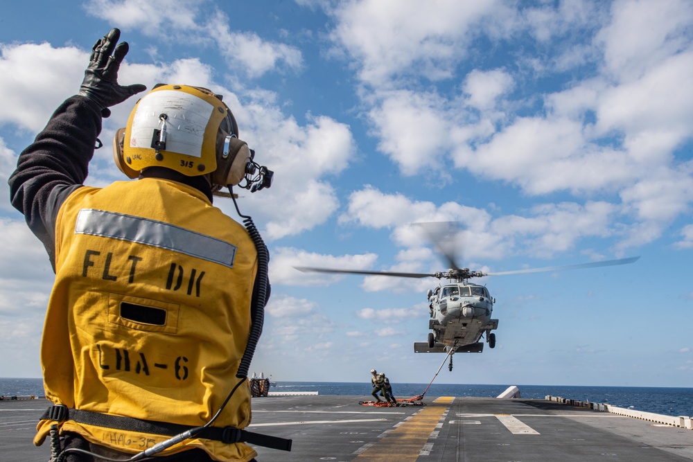 USS America conducts a vertical replenishment with the fleet replenishment oiler USNS Yukon (T-AO 202).