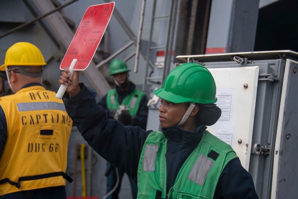 Sailor signals during underway replenishment