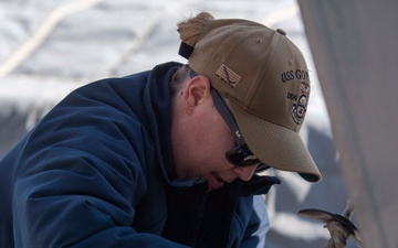 Sailor secures hoisting line to ship