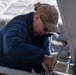 Sailor secures hoisting line to ship