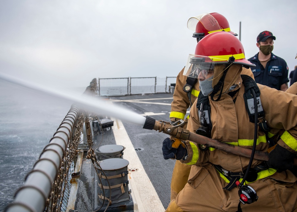 Operations Specialist 2nd Class Isaiah Marquez, from Lubbock, Texas, stands as the nozzleman of a hose team