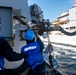 Sailors detach a fuel probe during a replenishment-at-sea