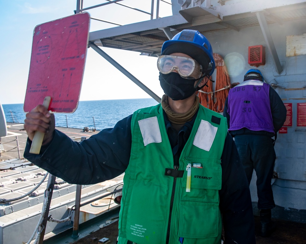 Seaman Tuo Li, from Warbin, China, serves as a signalman during a replenishment-at-sea