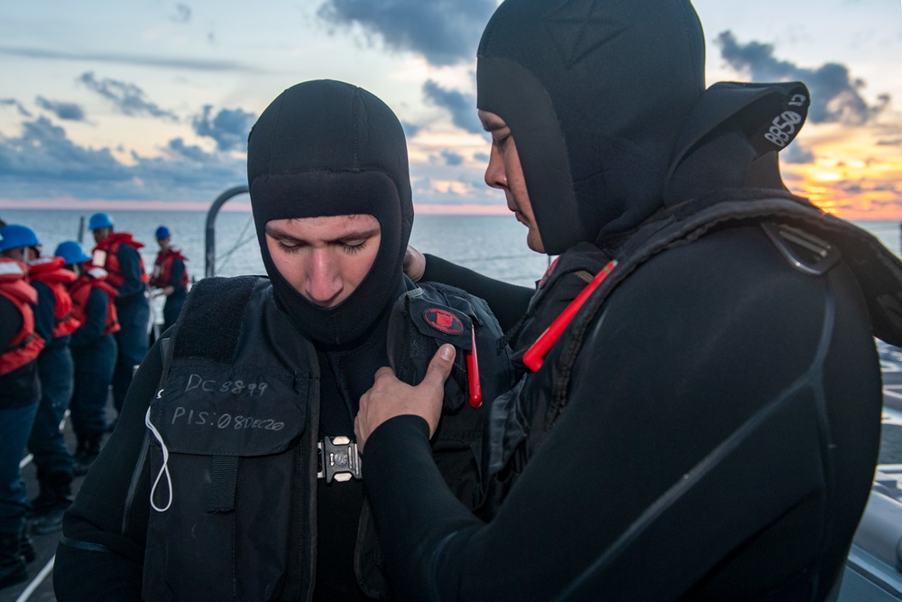 Logistics Specialist 2nd Class Bryce Braltierra (right), from Apache, Okla., helps Gas Turbine Systems Technician 3rd Class David Chiarizzi (left), from Long Island, N.Y., don Search and Rescue gear