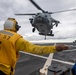Boatswain’s Mate 3rd Class Tra’shaun Cooper, from Homestead, Texas, directs a MH-60S Sea Hawk helicopter