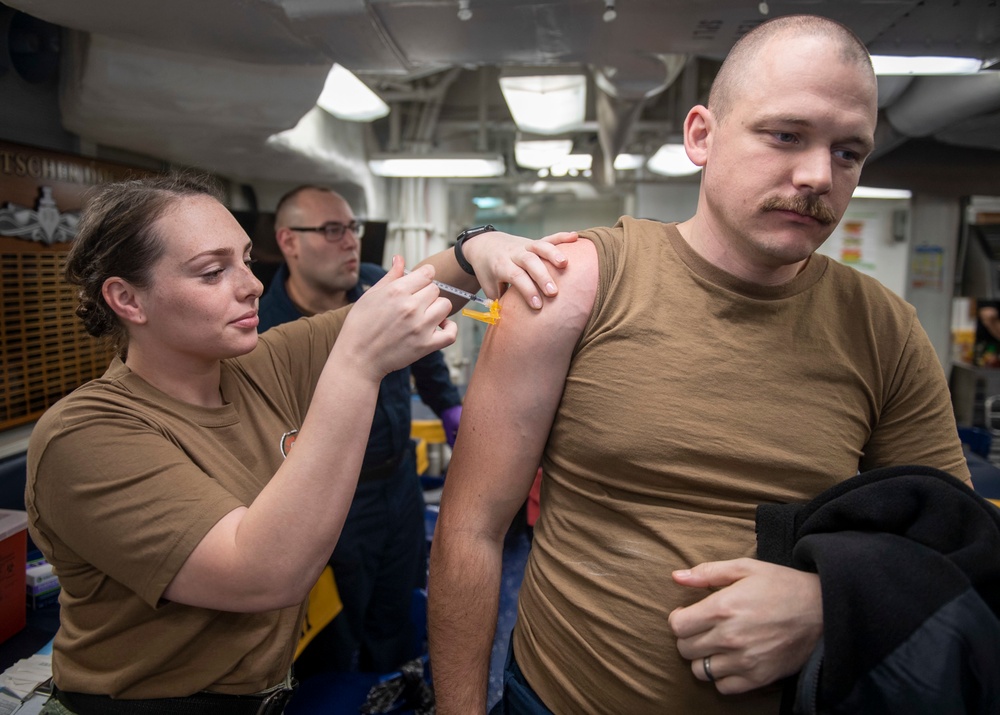 Hospital Corpsman 3rd Class Lauren Kestell (left), from Oklahoma City, Okla., assigned to USS Harry S. Truman (CVN 75), administers a COVID-19 booster to Chief Fire Controlman (AEGIS) Kellen Smothers (right), from Clio, Mich.