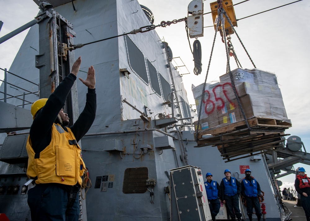 Boatswain’s Mate 3rd Class Tra’shaun Cooper, from Homestead, Texas, signals to the Supply-class fast combat support ship USNS Supply