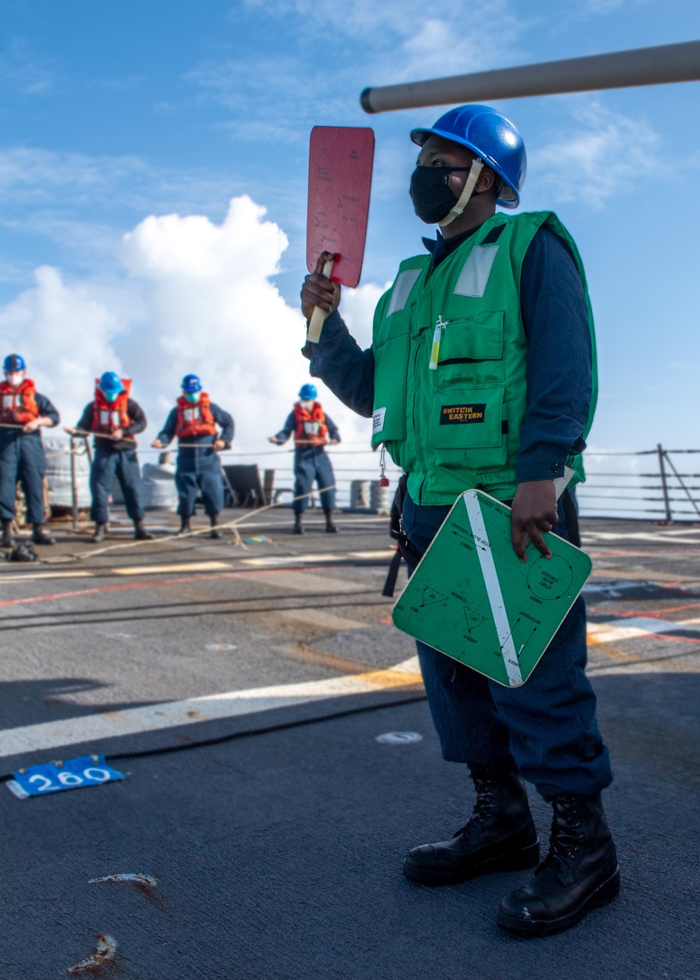 Sailor aboard Arleigh Burke-class guided-missile destroyer USS Mitscher (DDG 57) signals to Royal Canadian navy auxiliary replenishment oiler MV Asterix