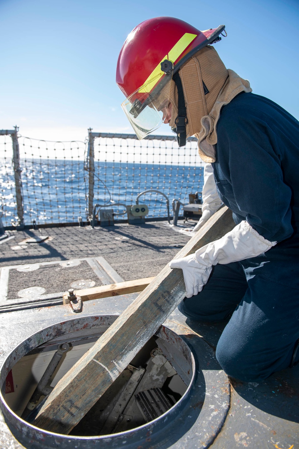 Damage Controlman Fireman Gerardo Vargasarellano, from Oklahoma City, Okla., transports wood shoring through a hatch