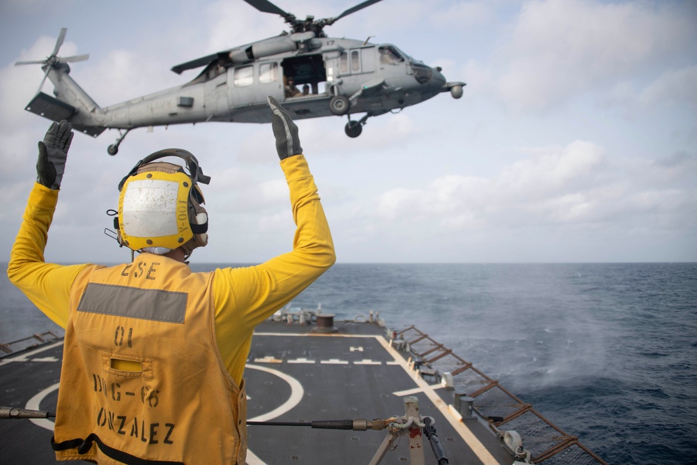 Sailor signals to aircraft aboard USS Gonzalez.