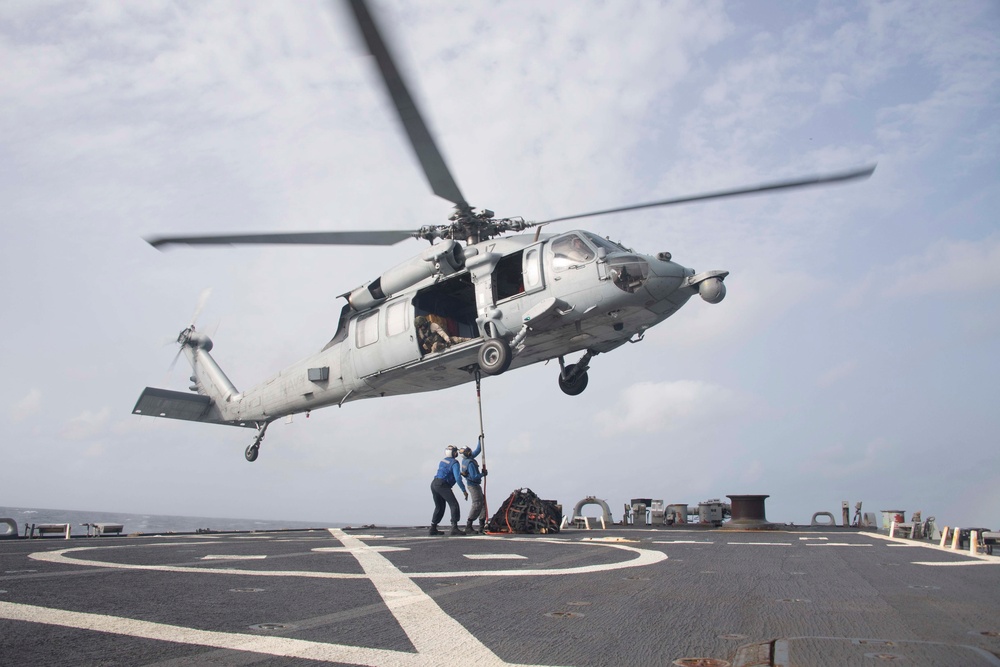 Sailors hook cargo to aircraft aboard USS Gonzalez.