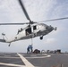 Sailors hook cargo to aircraft aboard USS Gonzalez.