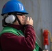 Sailor communicates through sound powered telephone during a replenishment-at-sea.