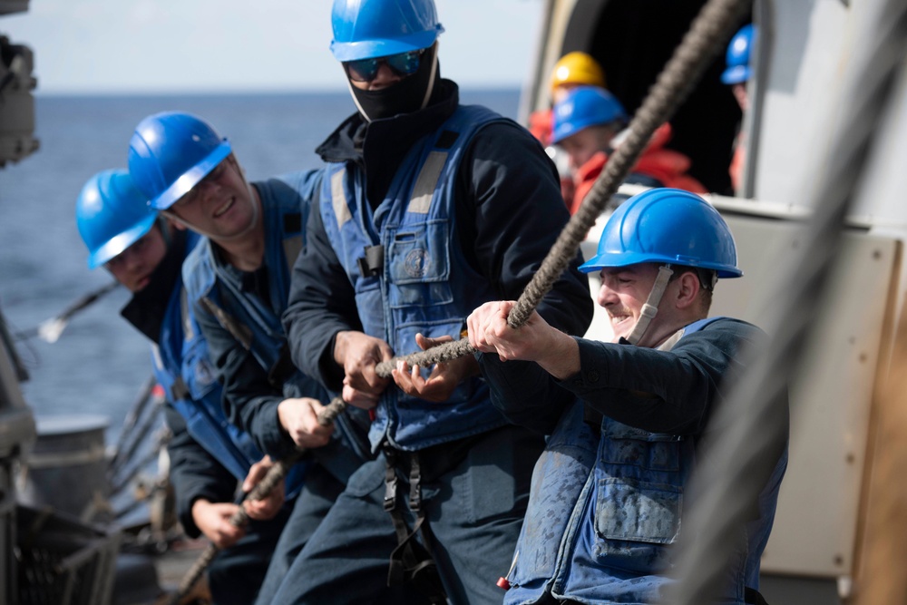 Sailors heave line during a replenishment-at-sea.