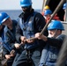 Sailors heave line during a replenishment-at-sea.