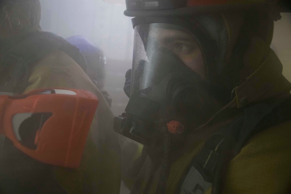 Sailor looks through naval firefighting thermal imager.