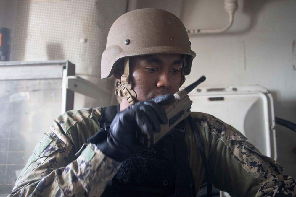 Sailor communicates using a hand-held radio during a VBSS drill.