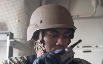 Sailor communicates using a hand-held radio during a VBSS drill.