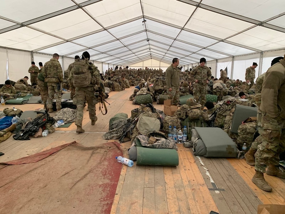 82nd Airborne Division place their equipment inside a tent as they settle in to their new location