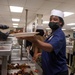 U.S. Navy Culinary Specialist Jenae Williams, from Williamsburg, Virginia, serves food at the Black History Month commemorative lunch