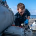 Gunner’s Mate 3rd Class Sebastian Demarais, from Portsmouth, Va., conducts maintenance on a Mark-32 surface vessel torpedo tube