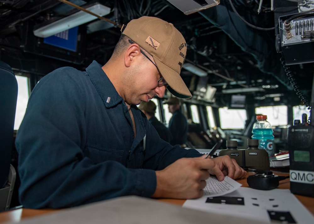 Lt. j.g. Daniel Galvan, from Houston, Texas, writes an entry into a log book