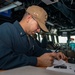 Lt. j.g. Daniel Galvan, from Houston, Texas, writes an entry into a log book